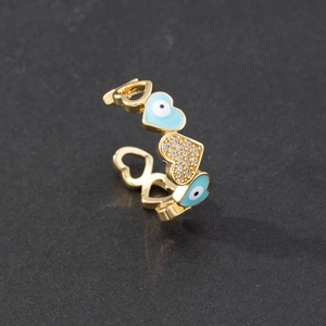 Macro detail of gold-plated open ring with blue enamel evil eye and zirconia hearts