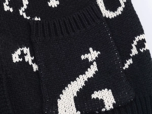 Detailed view of the jacquard knit texture and ribbed pocket on black and white cardigan