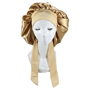 Close-up of champagne gold satin bonnet with adjustable ties on a model head