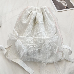 Close-up of white lace drawstring backpack with pink satin ribbon and floral trim
