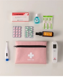 Pink portable first aid kit bag organized with medical supplies on light background