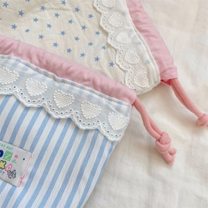 Detail of cute lace trim and pink drawstring on striped fabric storage pouch