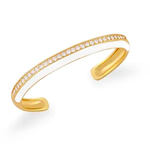 Dettaglio del bracciale dorato a C con smalto bianco e micro-pavé di zirconi cubici