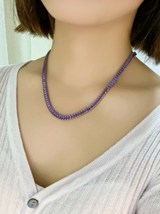 Detailed view of elegant purple zircon tennis necklace worn by a fashion model