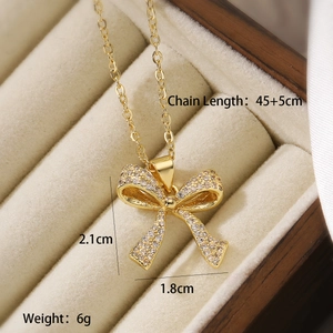 Detail showing the 45+5cm chain length and 2.1x1.8cm gold bow pendant with zircon