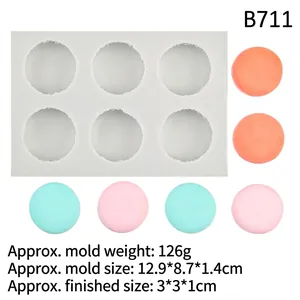 Detailed view of white 6-cavity silicone macaron mold with round finished products
