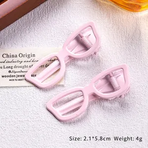 Close-up showing pink sunglasses shaped hair clips with sturdy metal alligator base
