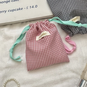 Checkered drawstring storage bag in red and black cotton fabric with fabric cords