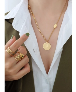 Detail of French vintage 18k gold plated portrait coin necklace and rings on model