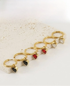 Detail view of heart-shaped zircon hoop earrings in black, red, and clear colors