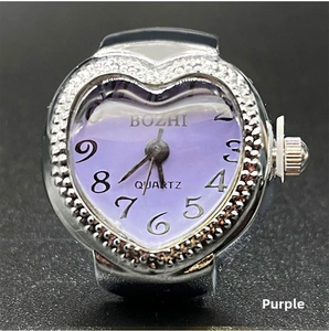 Detailed close-up of heart-shaped quartz ring watch with purple dial and crystal bezel