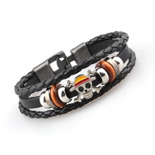 Detail of multi-layer leather bracelet with One Piece skull charm and silver clasp
