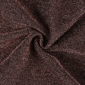 Gros plan sur le tissu pailleté bronze avec éclat métallique et détails de drapé doux