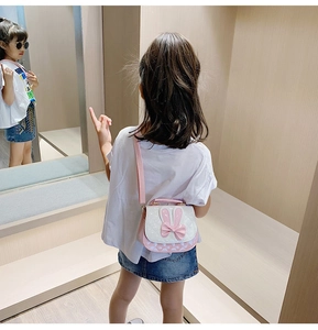 Detailed back view of pink and white girl's rabbit ear handbag with bow decoration
