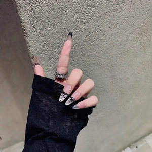 French lace press-on nails with black bows and polka dots on long stiletto tips