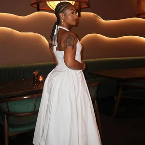 Detail of elegant white halter neck backless dress worn in a stylish restaurant setting