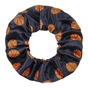 Dark blue satin hair scrunchie with orange basketball patterns on white background