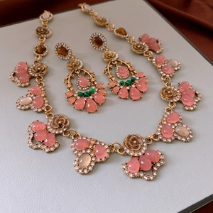 Detail of vintage gold flower jewelry set with pink teardrop stones and crystals