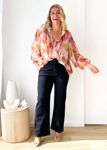 Vue détaillée du chemisier imprimé à manches longues avec un pantalon bleu foncé à jambes larges