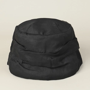 Détail du chapeau cloche en lin noir avec plis élégants et finition satinée légère