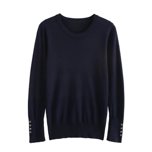Detail of navy knit top featuring chic silver decorative buttons on the sleeve cuffs