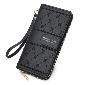 Detail of black leather long wallet with diamond quilted pattern and wrist strap closure
