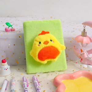 Close-up of soft green plush notebook with 3D yellow chick doll on the cover