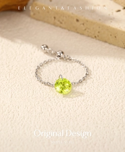Macro view of S925 silver chain ring with a hanging olive green zircon pendant