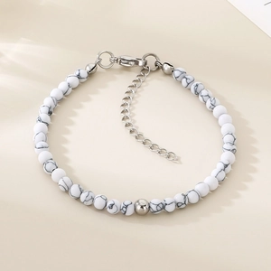 Détails des perles texturées en marbre blanc et fermoir mousqueton argenté sur un bracelet