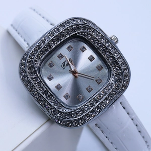 Close-up of the square silver dial with diamond-set bezel and white leather strap