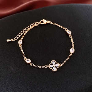 Detailed shot of gold plated bracelet featuring oval zircons and a clover leaf charm