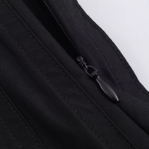 Détail de la fermeture éclair noire invisible et texture sergé sur une jupe midi plissée
