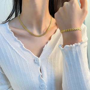 Elegant gold titanium steel jewelry set featuring a floral chain necklace and bracelet
