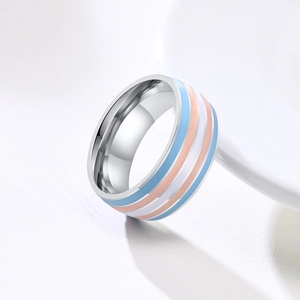Detailed view of a polished stainless steel ring featuring trans pride flag colors