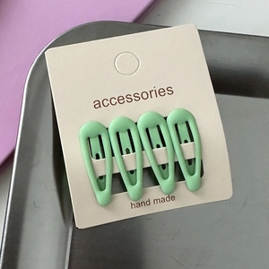 Set of four green star hair clips for girls displayed on a handmade accessory card