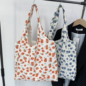 Detail view of durable canvas tote bags featuring orange and blueberry floral prints