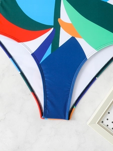Close-up of color-block swimsuit featuring tropical leaf prints and double-stitched seams