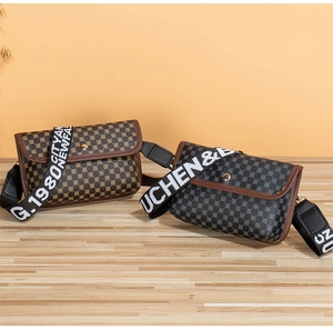 Detailed view of two square crossbody bags with embroidered wide straps on wooden base