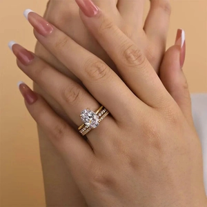 Detail eines eleganten goldenen Hochzeitsring-Sets mit ovalem Hauptstein und Pavé-Band