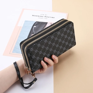 Detail of a women's long wallet with double zipper and floral pattern with a wrist strap