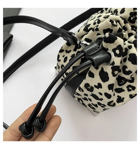 Close-up of drawstring closure and leopard print canvas texture on bucket bag