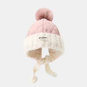 Pink quilted knit winter hat for kids with earflaps and a fluffy pom pom