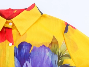 Detail of floral chiffon shirt collar with yellow print and white button closure