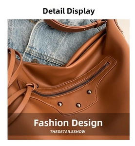 Detail of brown leather tote featuring vintage metal rivets and zipper accents