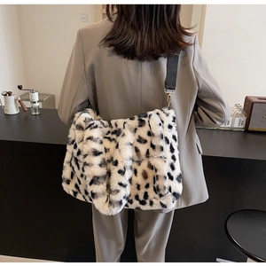 Close-up of leopard print plush tote bag with black strap on a shoulder