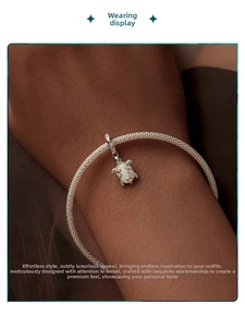 Detailed view of an S925 silver mesh bracelet with a glowing turtle charm on wrist