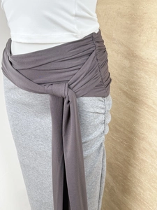 Detail of light gray knit skirt featuring deep coffee drawstring waistband and side pleats