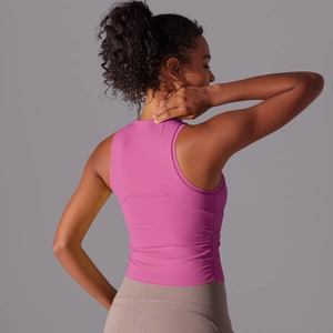 Détail du débardeur de sport rose plissé avec coutures au dos pour le yoga et le fitness