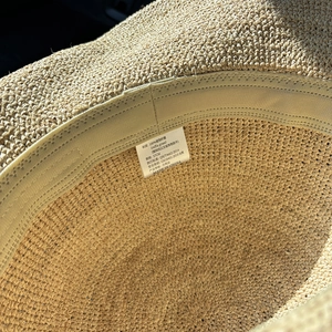 Detail eines Hutes aus 100% Raffia-Stroh mit Innenfutter und Materialetikett