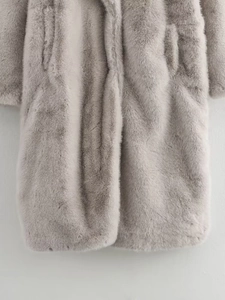 Gros plan sur la texture douce et les fibres denses d'un long manteau en fausse fourrure